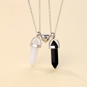 Detail of magnetic heart couple necklaces with black and white hexagonal pendants
