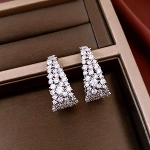 Gros plan de boucles d'oreilles en U argentées avec zircons sertis en micro-pavé