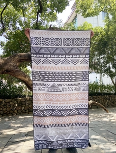 Outdoor view of quick-dry beach towel featuring ethnic geometric patterns and colorful design