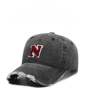 Detail of vintage gray baseball cap featuring distressed brim and embroidered N patch