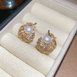 Detailed close-up of a 18k gold plated pearl earring with sparkling micro zircon stones