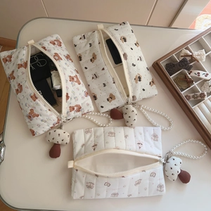 Detail of quilted cotton makeup bags with cute bear prints, pearl handles and mushroom charms