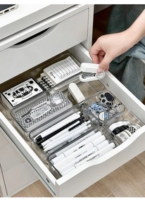 Macro view of transparent acrylic drawer organizers with modern stationery set