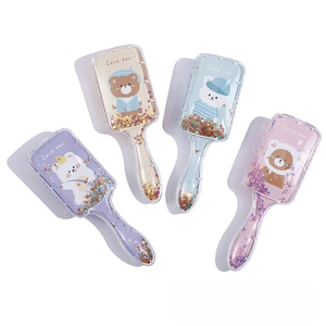 Detail of four colorful cartoon paddle brushes with glitter sequins and bear prints
