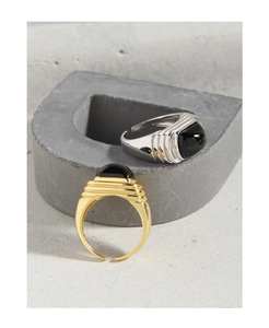 Macro detail of industrial style silver and gold rings with black onyx step design