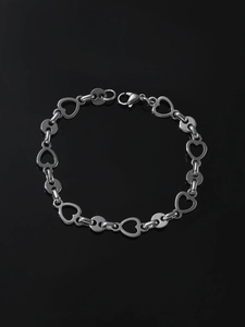 Detail of silver stainless steel bracelet featuring hollow heart links and lobster clasp