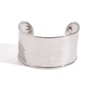 Macro shot of silver wide cuff bracelet featuring handcrafted hammered metal texture