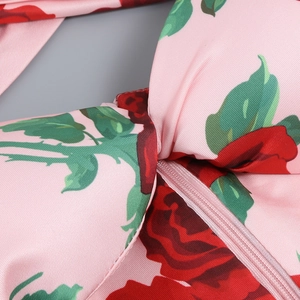 Close-up of pink floral dress featuring red rose print and high-quality hidden zipper