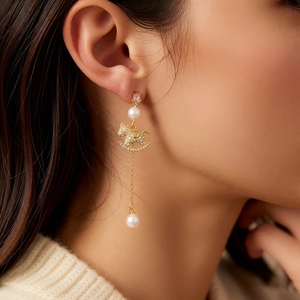 18k gold plated horse pendant earrings with pearls and tassels shown on a model
