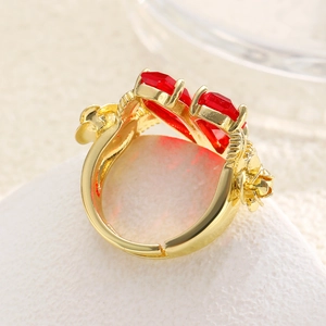 Detail of adjustable gold ring featuring two red heart stones and 3D floral accents