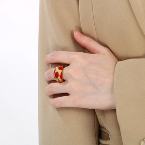Chic gold-plated stainless steel wide ring with red enamel polka dots on index finger