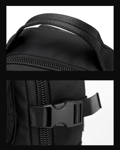 Detail view of the black nylon shoulder bag showing the top handle and side buckle straps