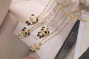 Detailed view of gold pearl panda and bear pendant necklaces on a luxury magazine background