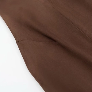 Vue détaillée de la texture en daim marron foncé et des coutures précises du gilet