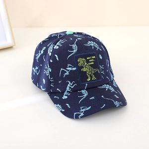 Detail of dark blue kids baseball cap showing dinosaur bone prints and embroidered patch