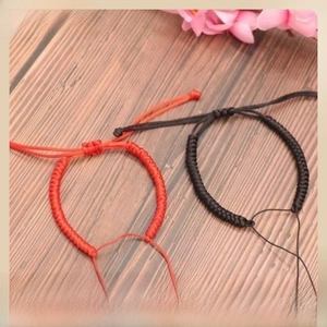 Detail of handmade braided red and black knot bracelets with adjustable sliders