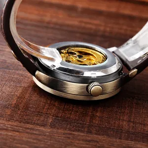 Detail of vintage bronze watch case with transparent back showing mechanical movement