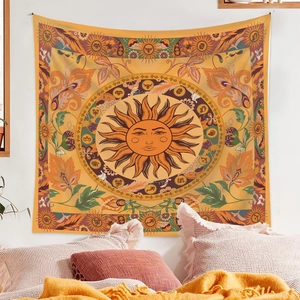 Detail of sun and moon tapestry with boho floral patterns hanging on a bedroom wall