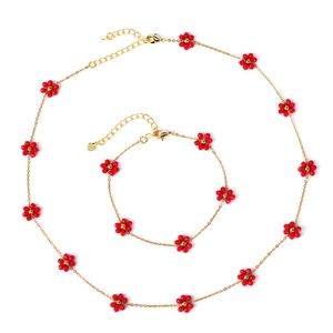 Gold chain jewelry set with red woven floral beads including necklace and bracelet
