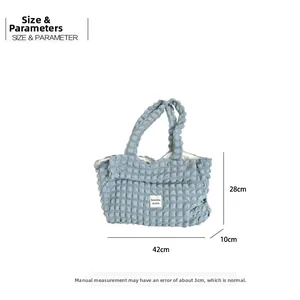 Detail of blue pleated bubble tote bag with waffle texture and Sozakka studio label