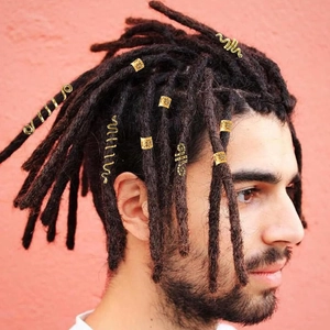 Close-up of golden alloy spiral serpent rings and spring clips on braided dreadlocks