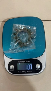 Kitchen scale showing the lightweight 10.7g weight of this rustic green napkin ring