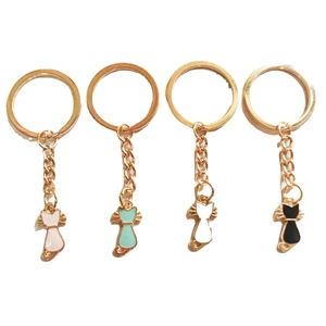 Set of four colorful enamel cat keychains in pink, green, white and black finishes