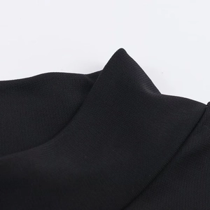 Détail du col d'une robe noire en maille montrant les coutures et la texture du tissu