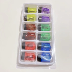 Macro view of twelve colorful transparent mini LED flashlight keychains in a tray