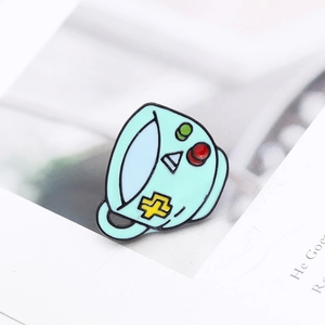 Detailed macro shot of a mint green robot teacup enamel pin on a white background