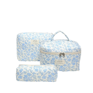 Three-piece quilted makeup bag set with blue floral pattern on white fabric base