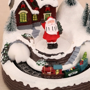 Macro view of Christmas music box with rotating train, Santa Claus and festive houses