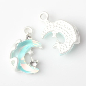 Macro shot of silver crescent moon pendant with blue resin and zircon inlay