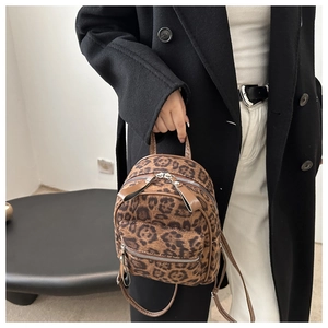 Detail eines Mini-Rucksacks mit Leopardenmuster, Doppelreißverschluss und Fronttasche am Modell
