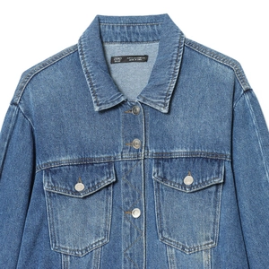 Classic blue denim jacket with front pockets and metal buttons on white background
