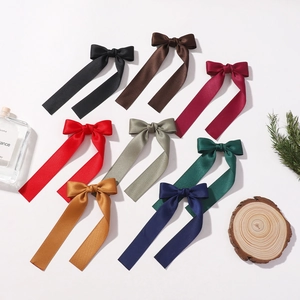 Set of 8 colorful satin ribbon bow hair clips with long streamers on a white background