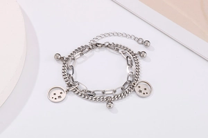 Detail of silver double-layer stainless steel bracelet with star charms and polished beads