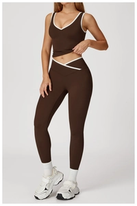 Detail of cross-over high waist leggings and contrast piping on the sports bra