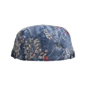 Close-up of vintage floral print on blue washed denim beret with side buckle details