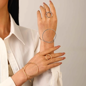 Ensemble minimaliste de bracelets et bagues géométriques or et argent sur un mannequin