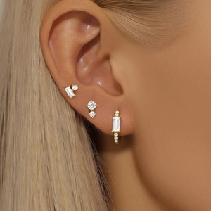 Close-up of three-piece gold S925 sterling silver hoop and stud earrings with zircon