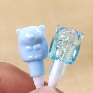 Detail of light blue cartoon bear headphone jack dust plugs in solid and clear resin