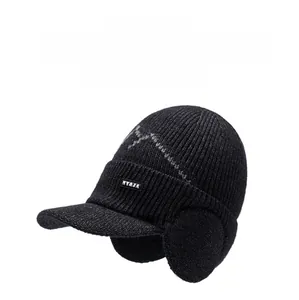 Detail view of black winter knit baseball cap with fold-down ear flaps and NY&JA logo