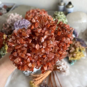 Close-up of handmade copper wire crystal money tree with orange natural stone leaves