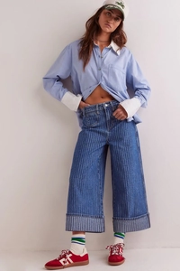 Nahaufnahme der gewaschenen gestreiften Jeans im Retro-Stil mit Hemd und Sneakern kombiniert