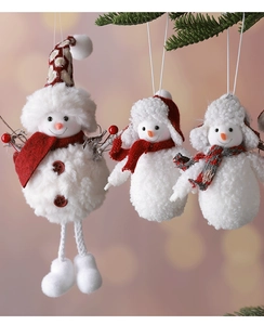 Detailed view of three white plush snowman ornaments with festive red knit hats and scarves