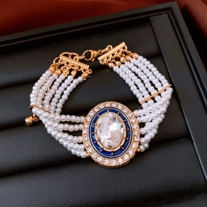 Macro view of multi-layer pearl bracelet with blue enamel and crystal pendant
