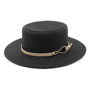 Detail of black straw boater hat texture with gold buckle and beige leather band