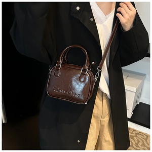 Detail of a dark brown mini square bag with embossed Yimeiya text and metallic hardware