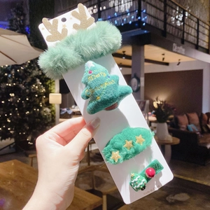 Detailed view of 4-piece Christmas hair clips set with green tree and sequin reindeer